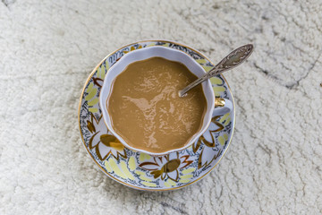 Closing a glass of freshly brewed coffee to an old white rustic table. Little depth of focus. Concept nostalgia.