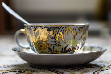 Closing a glass of freshly brewed coffee to an old white rustic table. Little depth of focus. Concept nostalgia.