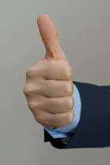 Businessman hand showing okey sign. On grey background.