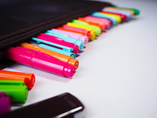 Fototapeta premium Close up Multi colored pens in pencil bag on a white background.