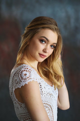 Naklejka premium Close up portrait of attractive blond girl in white knitted sweater
