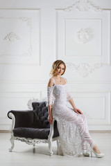 Fashion portrait of attractive blond girl in wedding white knitted dress with vintage background