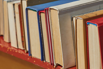 Old books on a wooden shelf. No labels