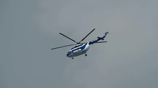 Russian Helicopter MI-8 flying high in the sky. Air transport helicopter with spinning blades. 