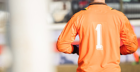 Soccer goalkeeper from behind view. Abstract background, close up, details, banner, space.