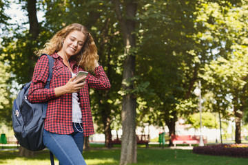 Beautiful female student using mobile smartphone outdoors