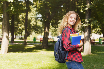 Happy female student standing in the park