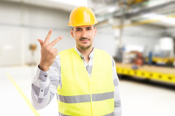 Handsome young factory worker or engineer showing number three.