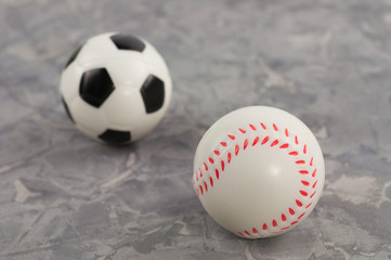 Two new soft rubber soccer and baseball balls on old worn cement