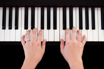 Woman playing piano. Top view with black isolate background. Art and music background.