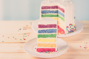 Obraz na płótnie Canvas Birthday background - striped rainbow cake with white frosting
