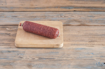 cheeses and sausage on wooden aged background.