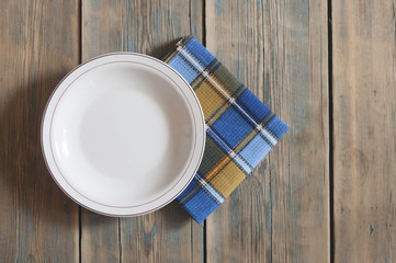 Blank white dish on a wood background.