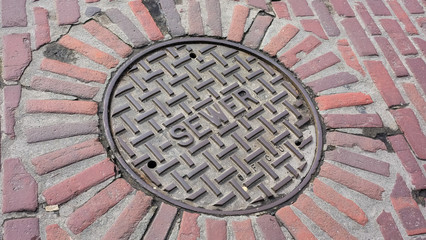 Sewer Manhole Cover On Brick Street