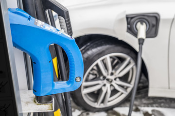 Fototapeta premium View of an Electric Car Charging and in the background a partial view of a car