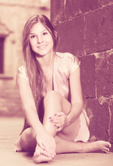 Naklejka premium young girl in romantic dress sitting in town