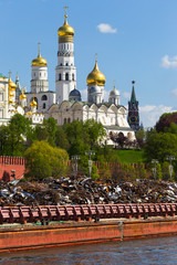 Russia, Moscow, the Kremlin, view from the side of Sofia embankment. Barge with scrap metal. May. Spring. Cathedrals of the Kremlin and Ivan the Great's bell tower.