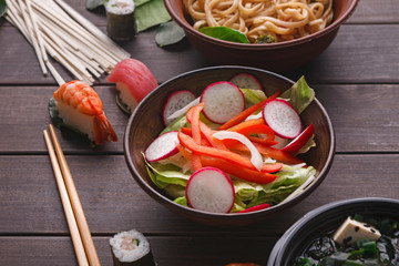Salad with onion, pepper and radish on wooden background