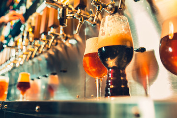 Hand of bartender pouring a large lager beer in tap.