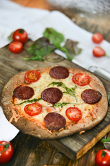 Mini Pizza With Cherry Tomatoes And Salami Sausages On A Wooden Background Natural Rustic, A Pizza Cutter And Ingridienty.