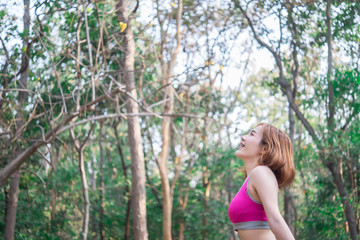 Naklejka na ściany i meble Asian sporty woman stretching arms breathing fresh air in the park,Thailand people exercise concept