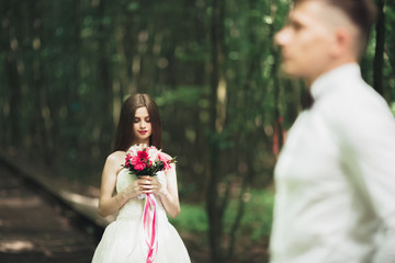 Obraz premium Bride posing and smiles while groom waits on the background