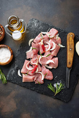 Raw chopped meat with spices on rusty background