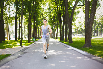 Young man running in green park, copy space