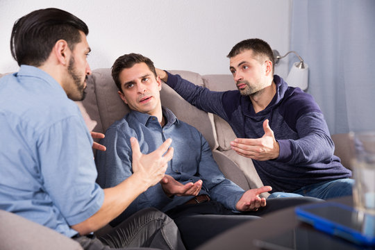 Two troubled men talking with friend
