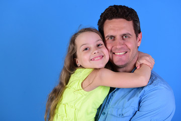 Fototapeta premium Childhood and family concept. Daughter and dad hug each other.