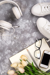 Summer holiday concept: smartphone , white sneakers, notepad, headphones, pen