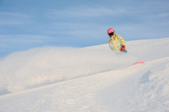 Female snowboarder sliding down the muntain hill