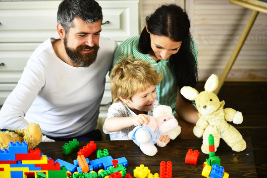 Mom, dad and boy play with white soft toys