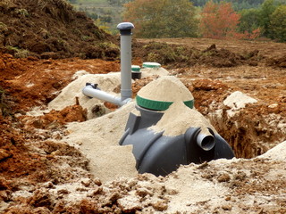 Filter, automatic flush and ventilation pipe components being installed as part of a sand and...