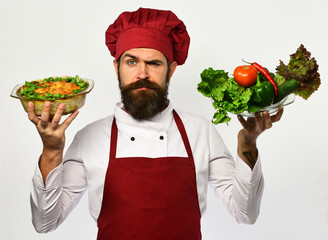 Cook with confused face in burgundy uniform holds baked dish