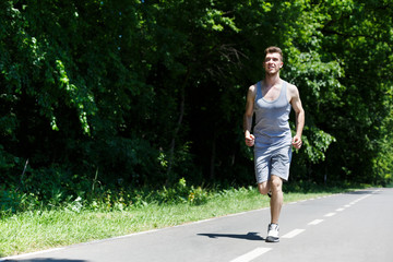 Young man jogging on treadmill in park, copy space