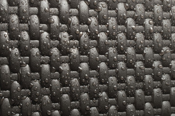 Obraz premium Drops of water on a dark background. Wicker texture