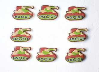 Homemade Gingerbreads in the form of tanks in protective khaki color on Defender of the Fatherland Day. Selective focus.