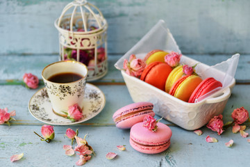 Dessert With Coffee: A Delicate Fresh French Macaroons In Pastel Colors Gift Box Flowers Roses On Light Blue Wooden Background