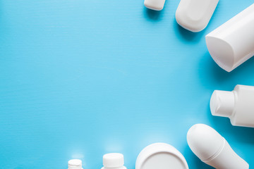 Different, white beauty toiletries on blue background. Mock up for special offers as advertising or other ideas. Cares about a men's, women's and kids hair and body skin. Empty place for text or logo.