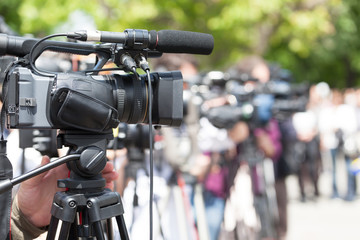 News conference. Filming media event with a video camera.