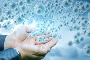 Hand of a businessman shows the molecules .