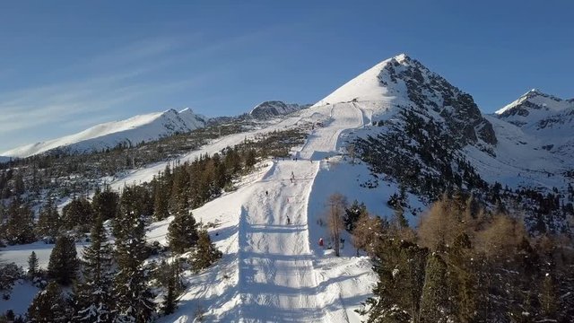 Aerial view of skiers on ski slope on Strbske Pleso resort in High Tatras mountains, Slovakia.