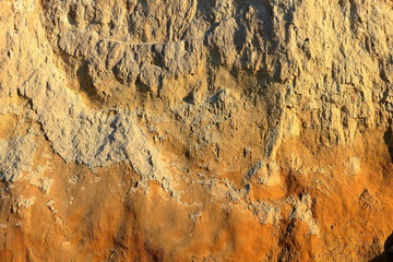 Detail of natural orange brown loamy (clay) soil of ravine wall with rough texture background
