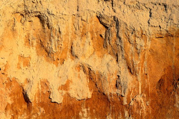 Detail of natural orange brown loamy (clay) soil of ravine wall with rough texture background