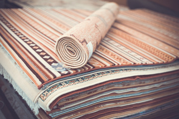 Stack of multicolored quality rugs  at carpet shop