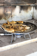 Fried fish steaks fried in metal dish outdoor