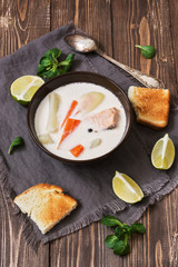 Scandinavian ,Norwegian fish soup on a rustic wooden background. Salmon soup with potatoes, carrots, cream. View from above.