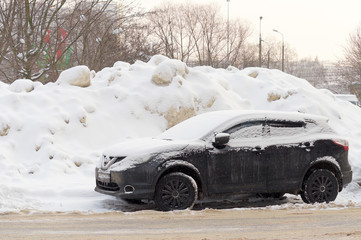 the car is parked after a heavy snowfall. Parked car covered with snow - snow storm, car after a heavy snowfall, a lot of snow on the car, car in the snowy yard.