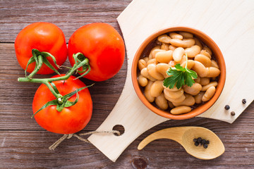 Cooked beans in tomato sauce in a bowl on the kitchen table. Top view